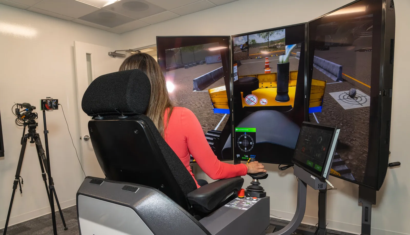 A student trying a heavy-equipment operating simulator during a career exploration event